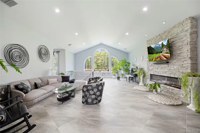 a living room with furniture a fireplace and a flat screen tv