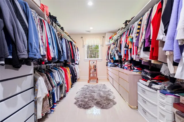 a view of walk in closet with clothes and shoes