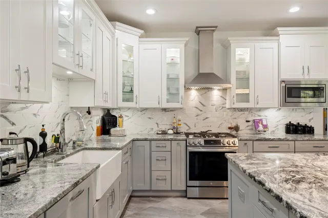 a kitchen with stainless steel appliances granite countertop a sink stove and cabinets