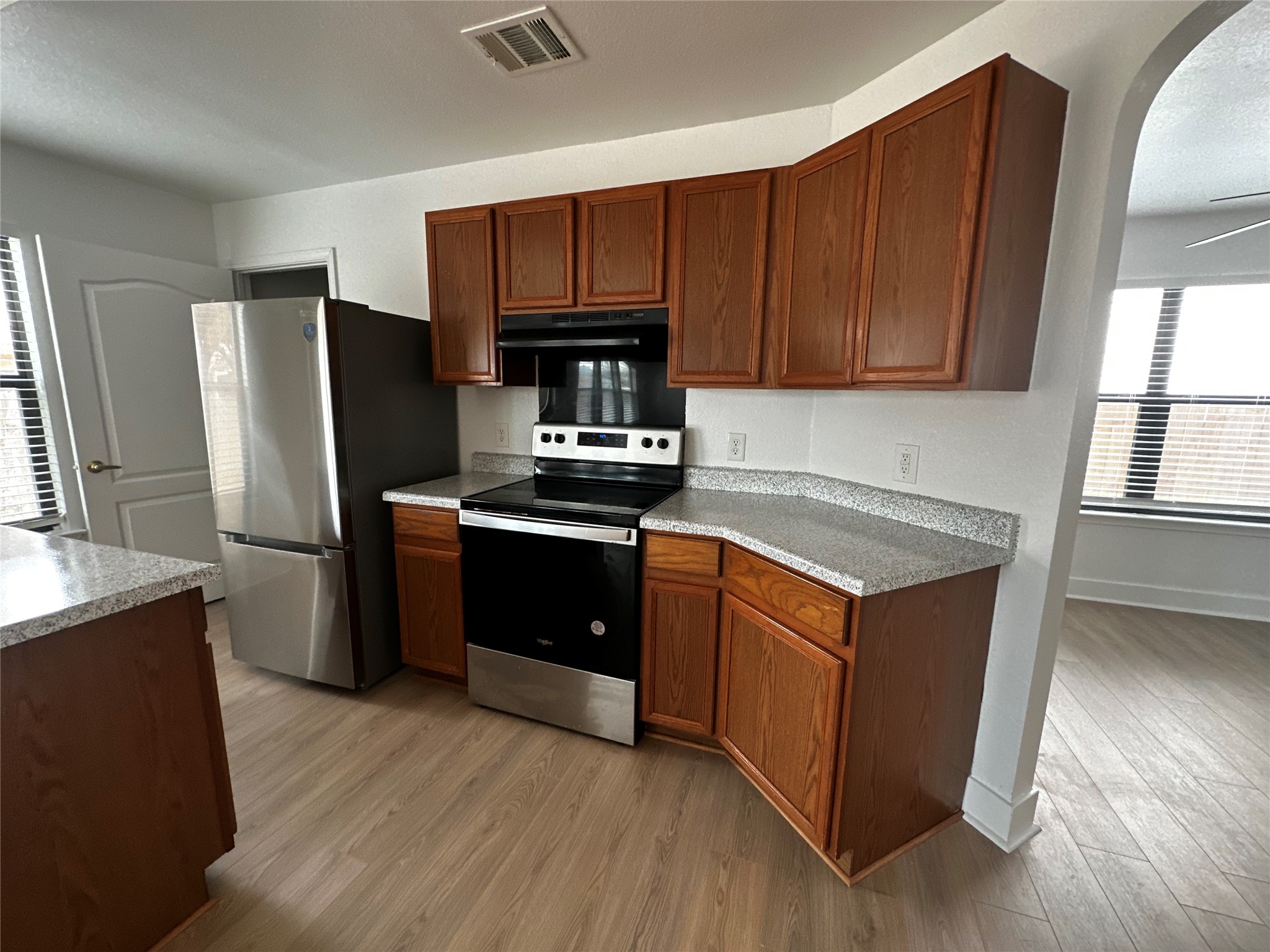 8016 Bannock Lane Austin, TX 78747 - Photo 9 of 32 a kitchen with wooden cabinets and stainless steel appliances