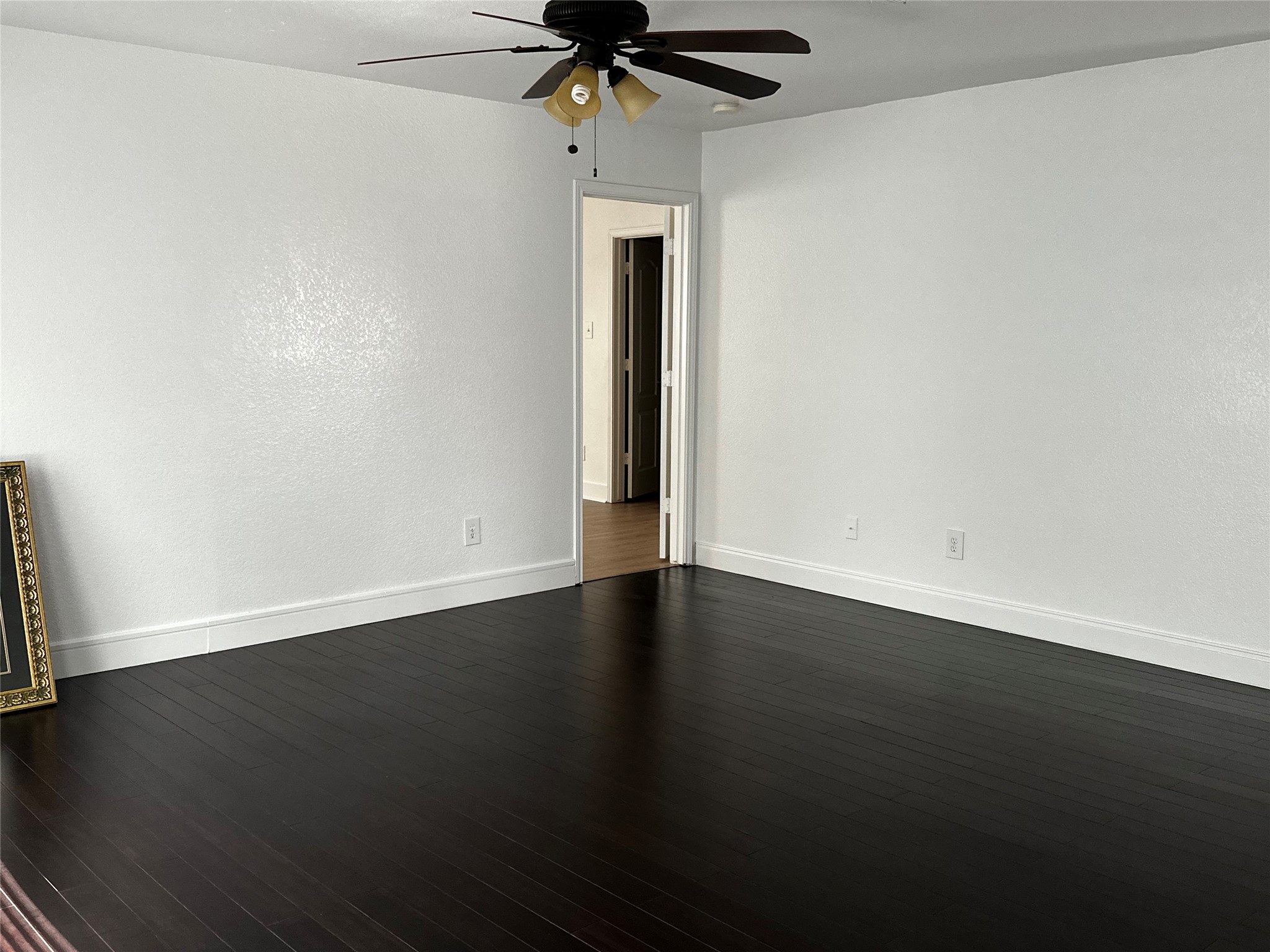 8016 Bannock Lane Austin, TX 78747 - Photo 14 of 32 a view of a room with wooden floor a ceiling fan and a window