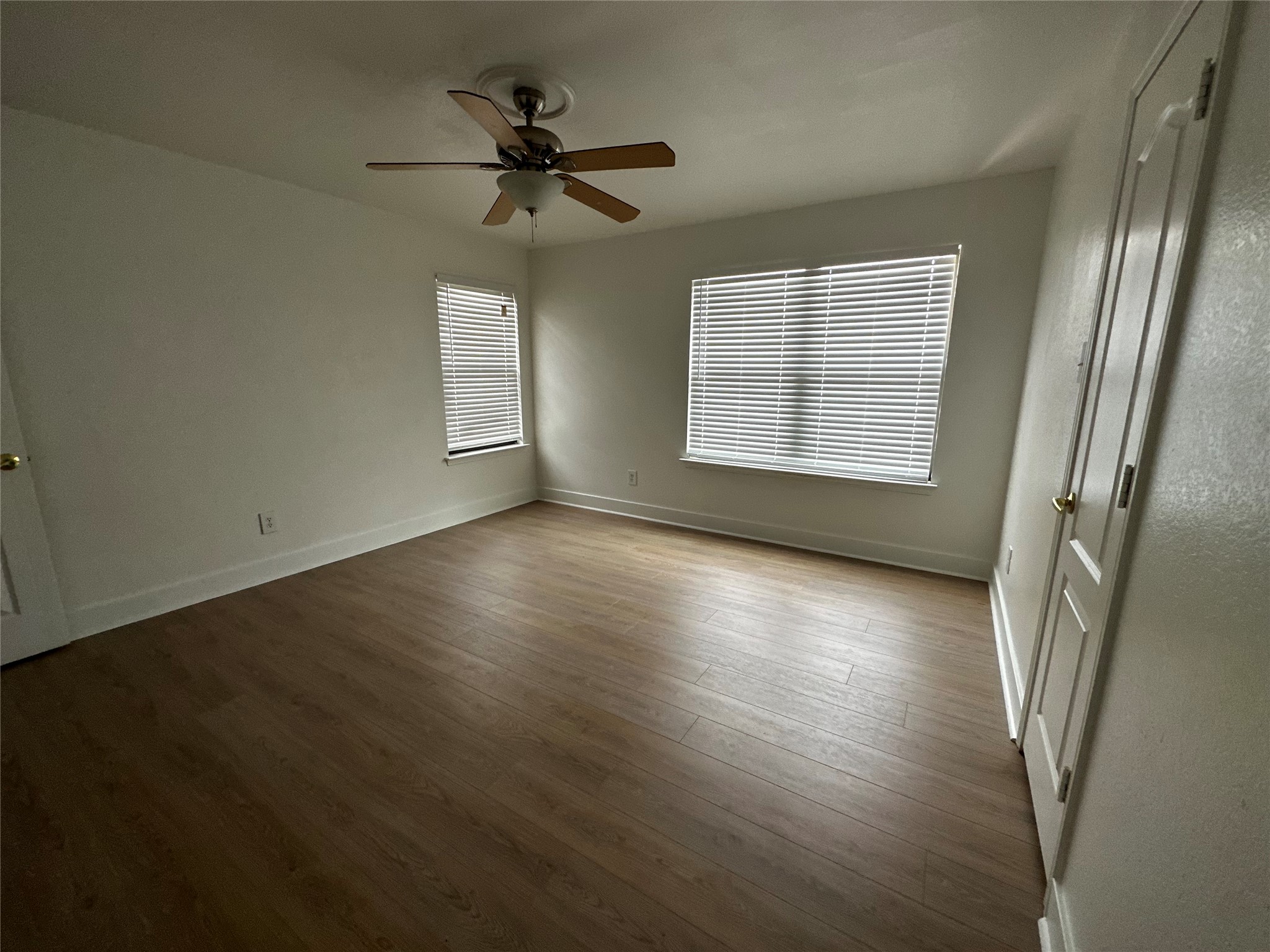 8016 Bannock Lane Austin, TX 78747 - Photo 21 of 32 an empty room with wooden floor fan and windows