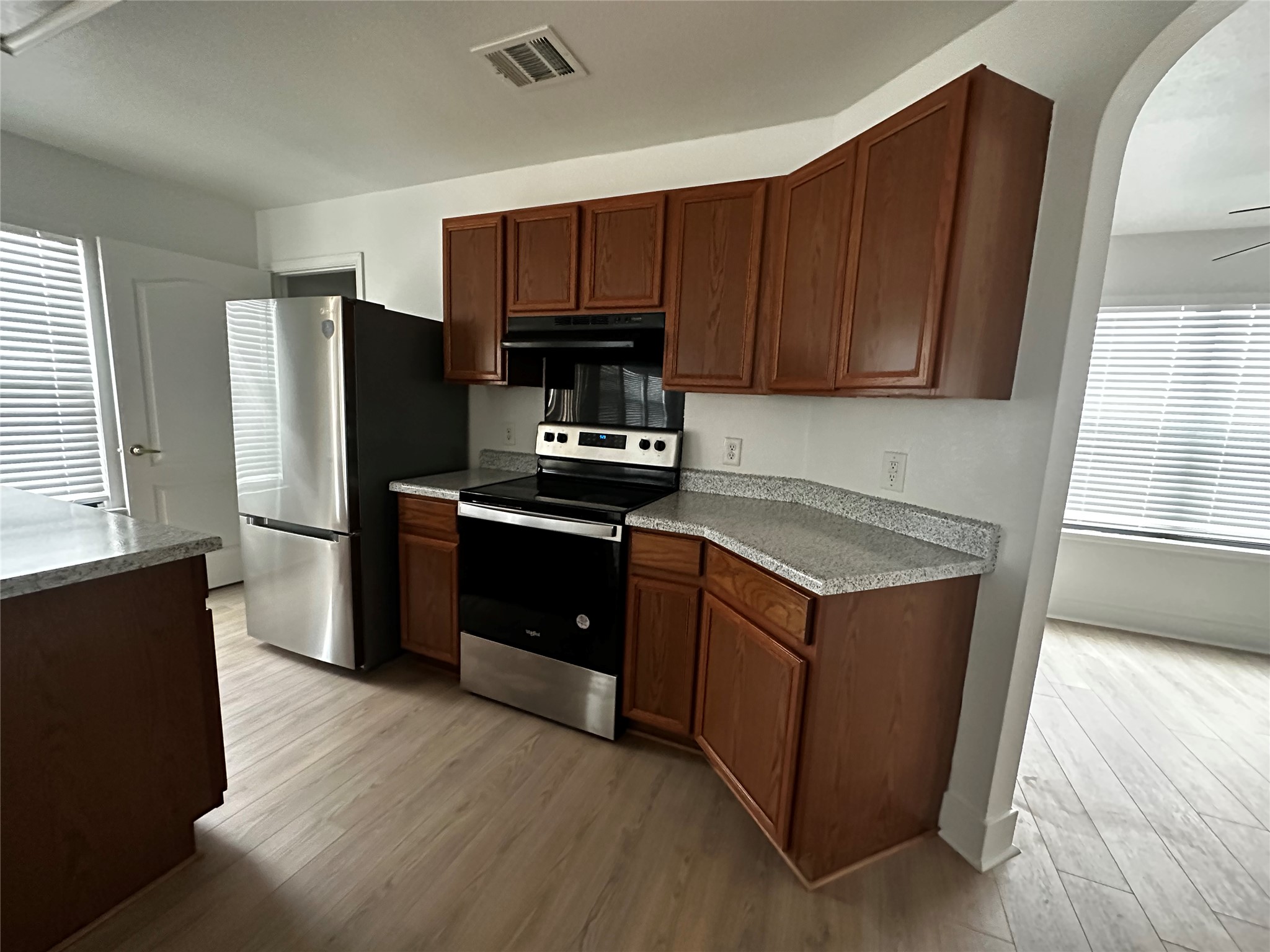 8016 Bannock Lane Austin, TX 78747 - Photo 7 of 32 a kitchen with wooden cabinets and stainless steel appliances