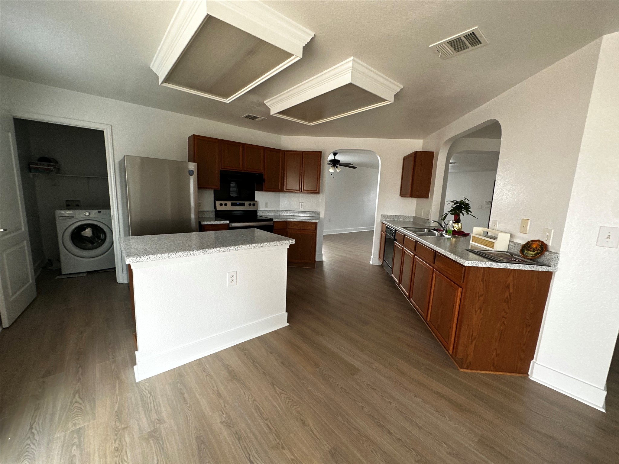 8016 Bannock Lane Austin, TX 78747 - Photo 8 of 32 a living room with stainless steel appliances kitchen island granite countertop wooden floors and a view of living room