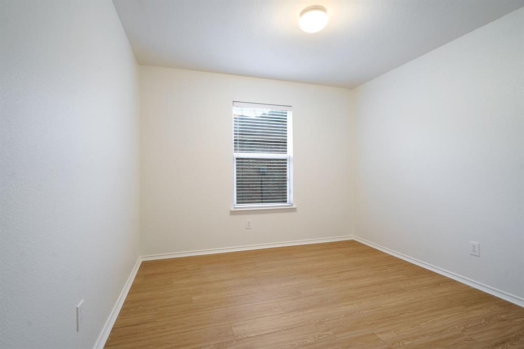 14813 North Spring Ridge Circle Balch Springs, TX 75180 - Photo 13 of 22 a view of an empty room with wooden floor and a window