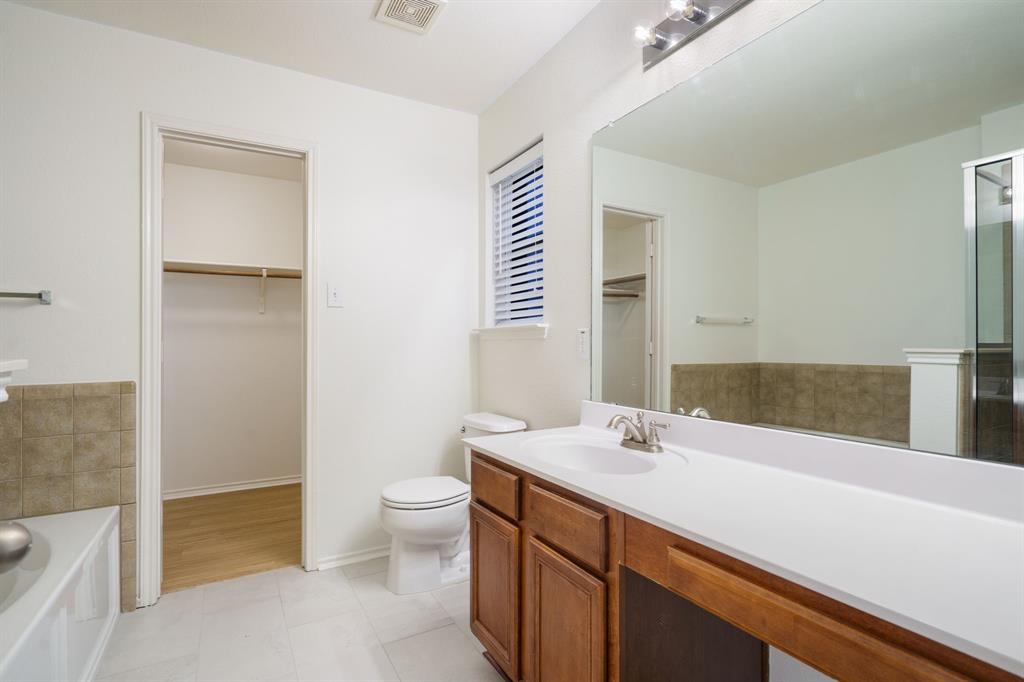14813 North Spring Ridge Circle Balch Springs, TX 75180 - Photo 18 of 22 a bathroom with a sink a toilet and a large mirror