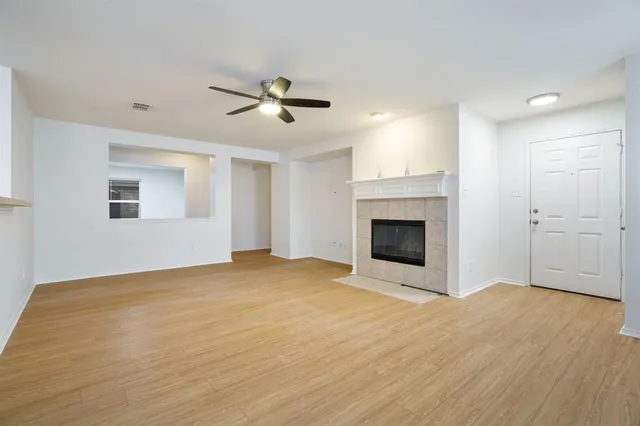 a view of empty room with wooden floor and fireplace