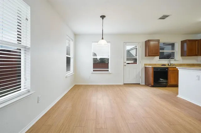 a view of a kitchen with a sink dishwasher oven window and wooden floor