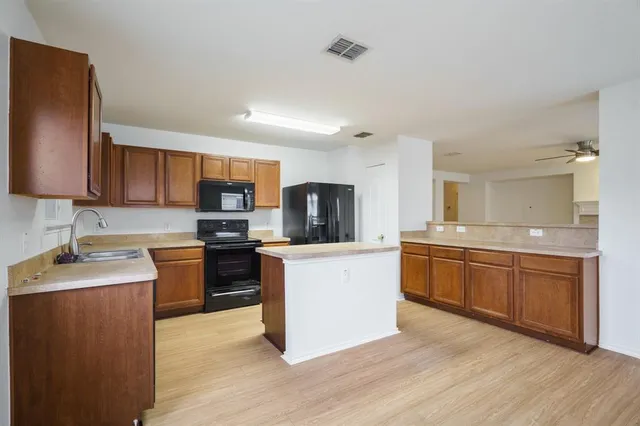 a kitchen with stainless steel appliances granite countertop a sink dishwasher stove top oven and refrigerator