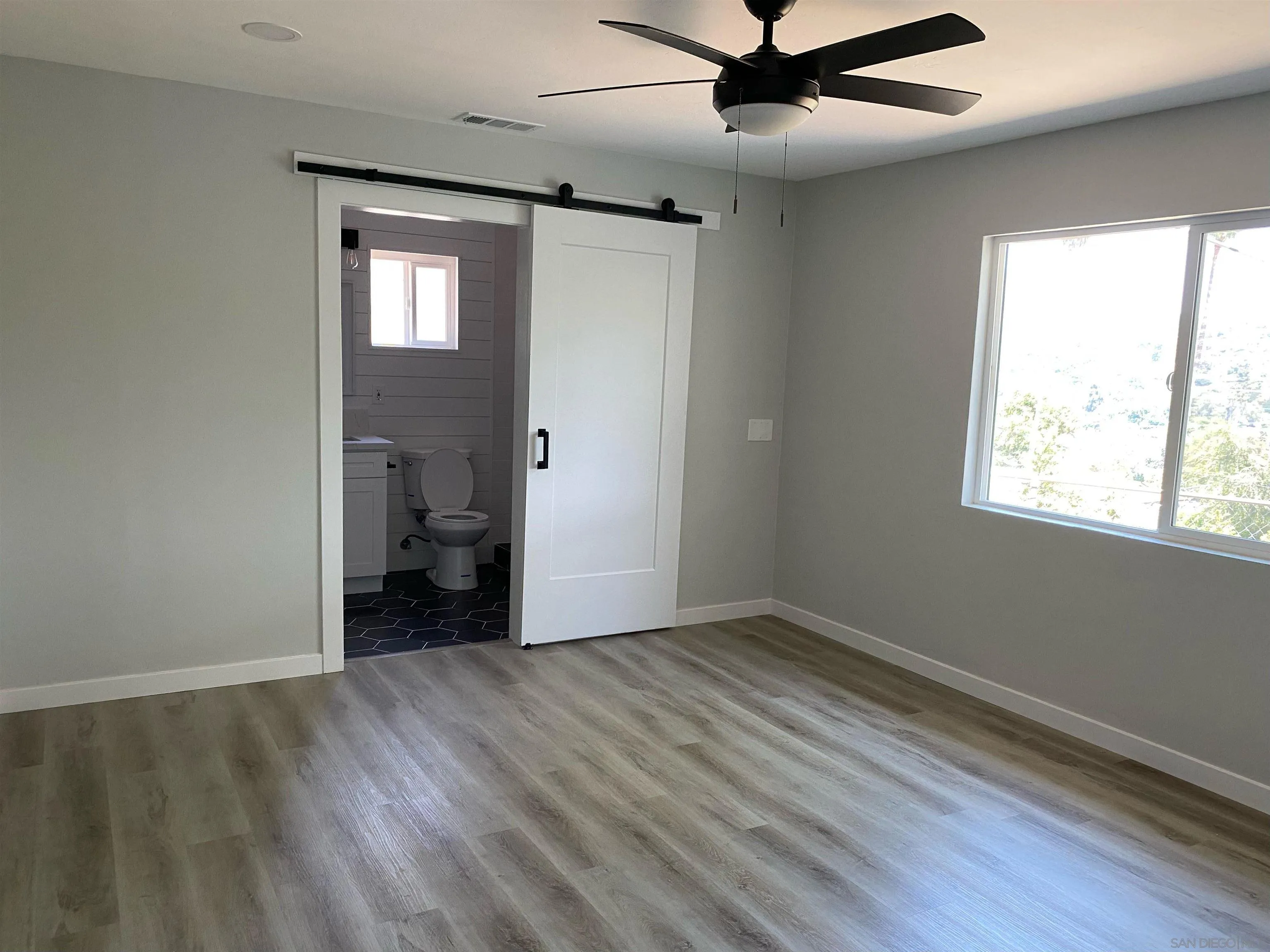 3866 Spring Drive Spring Valley, CA 91977 - Photo 4 of 9 a view of an empty room with a window and wooden floor