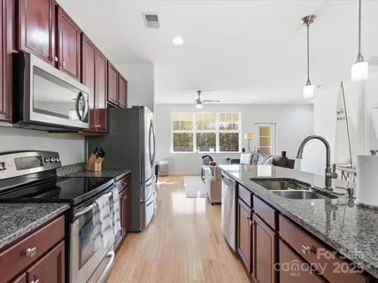 a kitchen with granite countertop stainless steel appliances a sink a counter space and cabinets