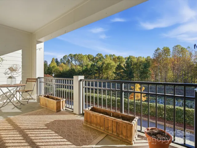 a view of a balcony with floor to ceiling windows yard and wooden floor