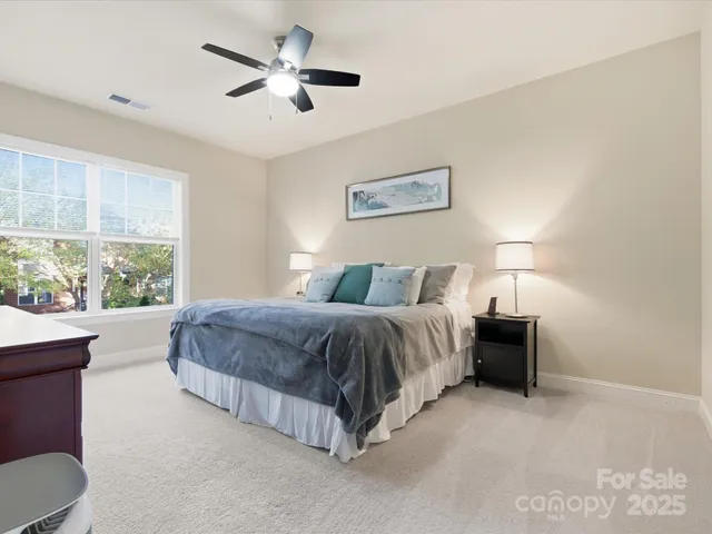 a spacious bedroom with a bed and a large window