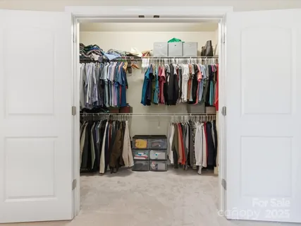 a view of walk in closet with clothes and shoes