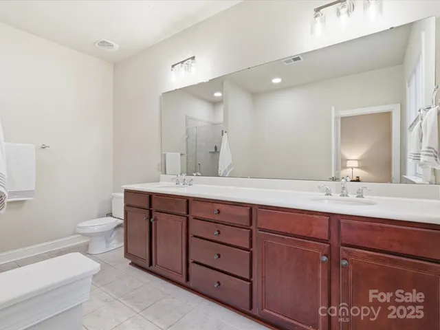 a bathroom with a double vanity sink and a toilet