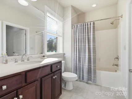 a bathroom with a double vanity sink toilet mirror and bathtub