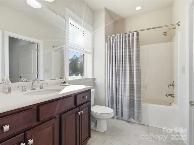 a bathroom with a double vanity sink toilet mirror and bathtub