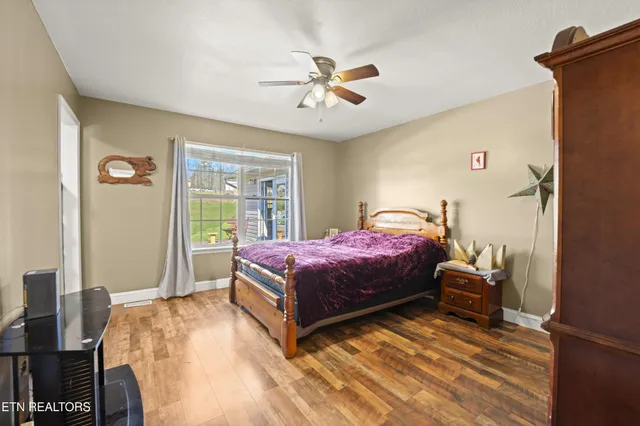 a spacious bedroom with a bed and wooden floor