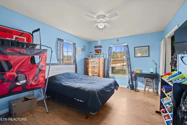 a bedroom with a bed and a bookshelf with wooden floor