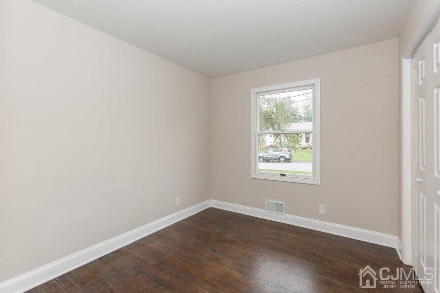 20 Brandeis Road Old Bridge, NJ 08859 - Photo 12 of 18 an empty room with wooden floor and windows