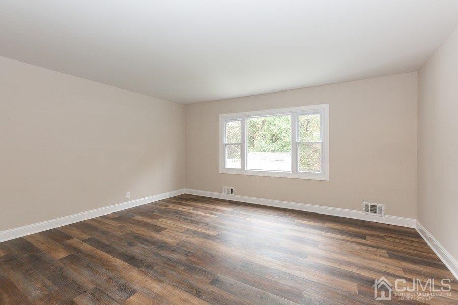 20 Brandeis Road Old Bridge, NJ 08859 - Photo 7 of 18 an empty room with wooden floor and windows