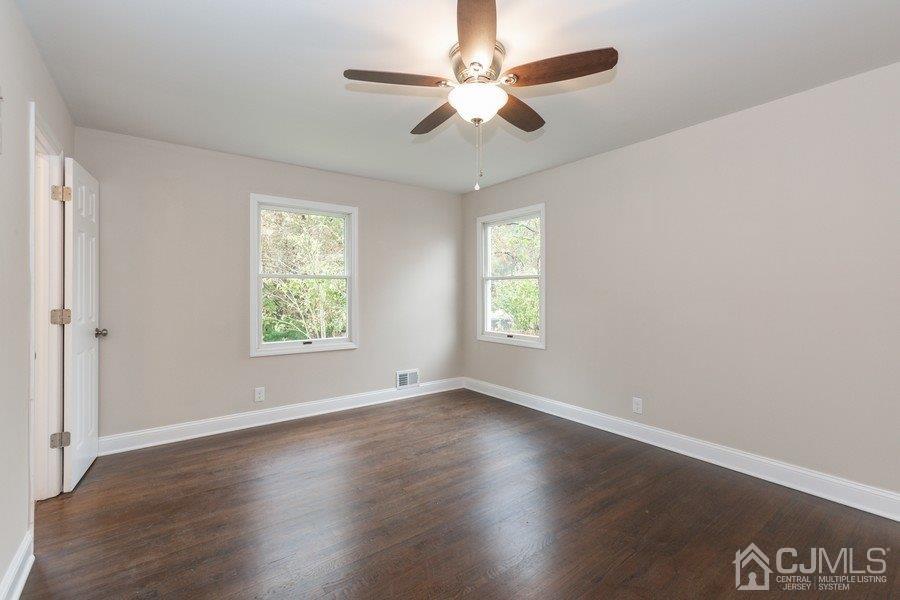 20 Brandeis Road Old Bridge, NJ 08859 - Photo 10 of 18 an empty room with wooden floor ceiling fan and windows