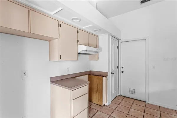 a view of cabinets and utility room with closet