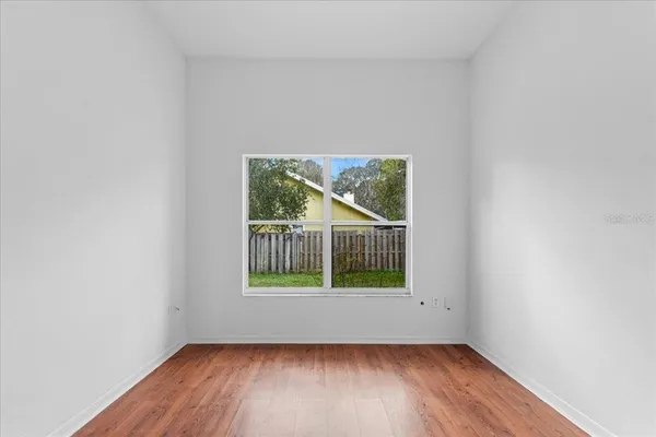 a view of a room that has wooden floor and a window