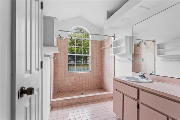 a bathroom with a shower sink and mirror