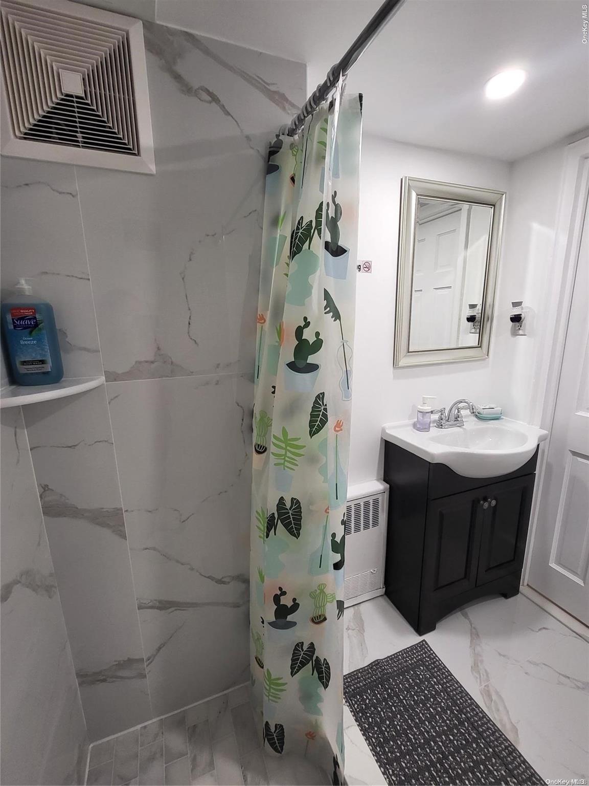 85-19 75th Street Queens, NY 11421 - Photo 4 of 17 a bathroom with a sink a toilet and shower