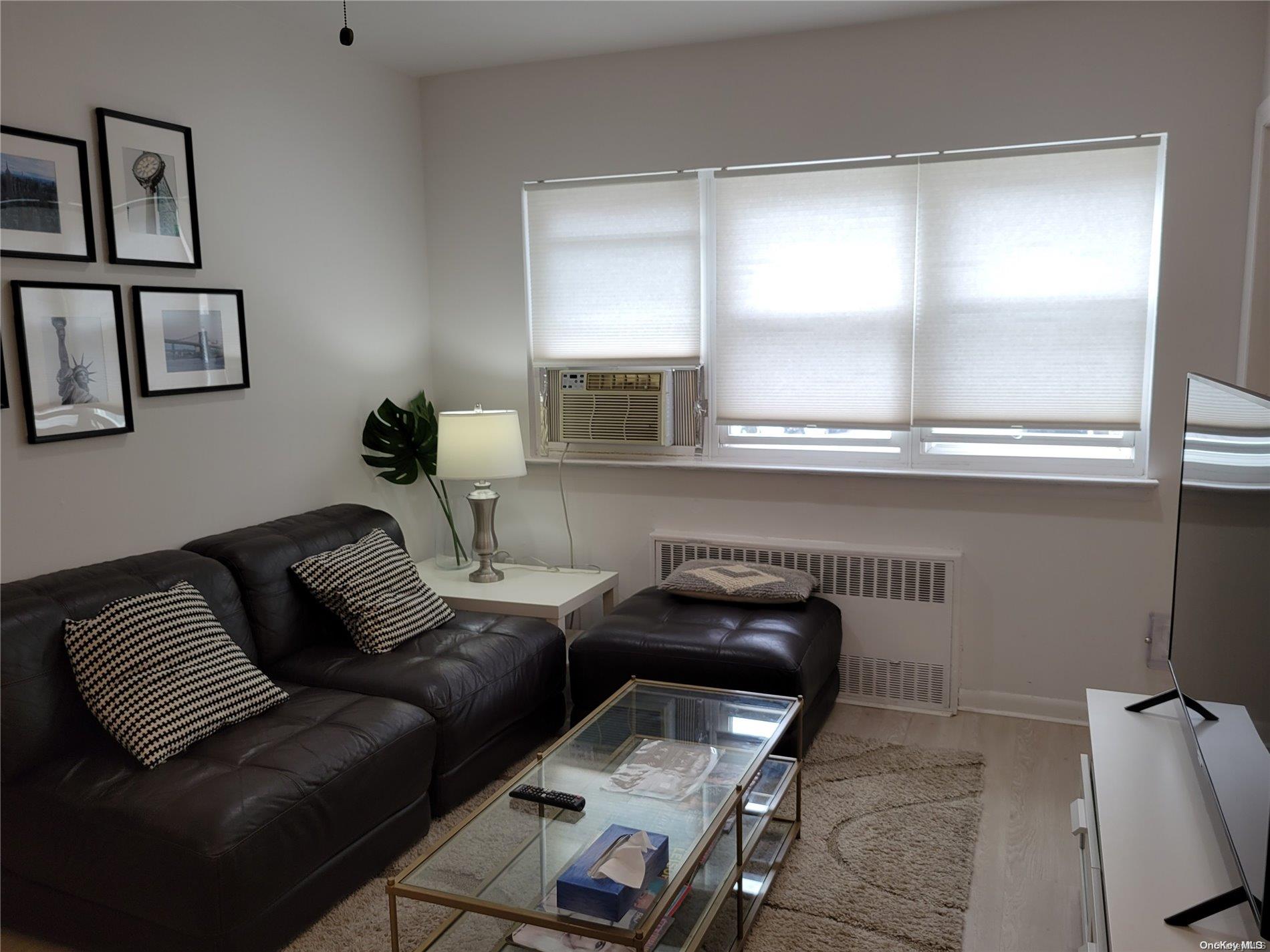 85-19 75th Street Queens, NY 11421 - Photo 9 of 17 a living room with furniture and a window