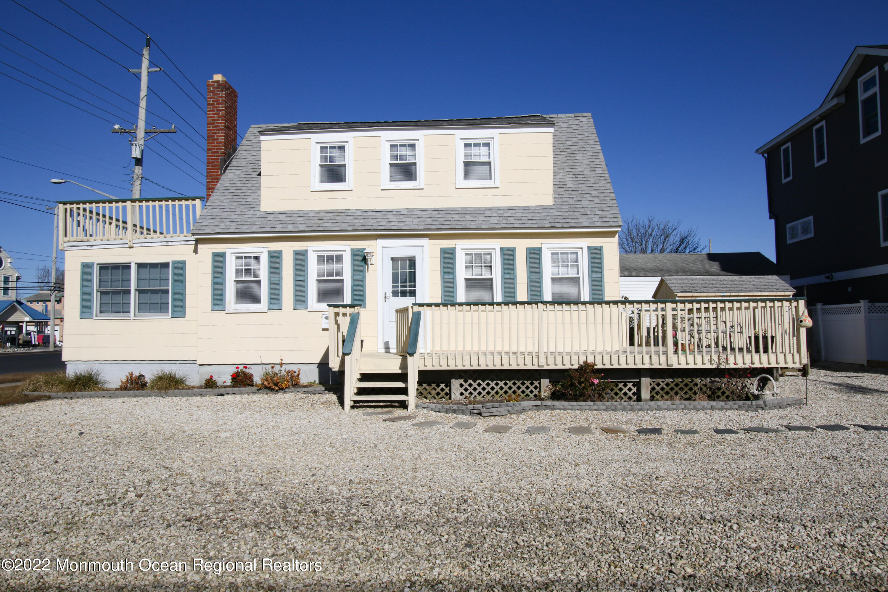 a blue house with tall trees in the background