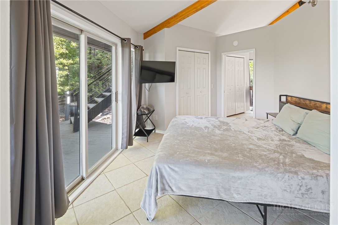 146 Cherokee Lane Purlear, NC 28665 - Photo 16 of 49 a spacious bedroom with a large bed and a chandelier