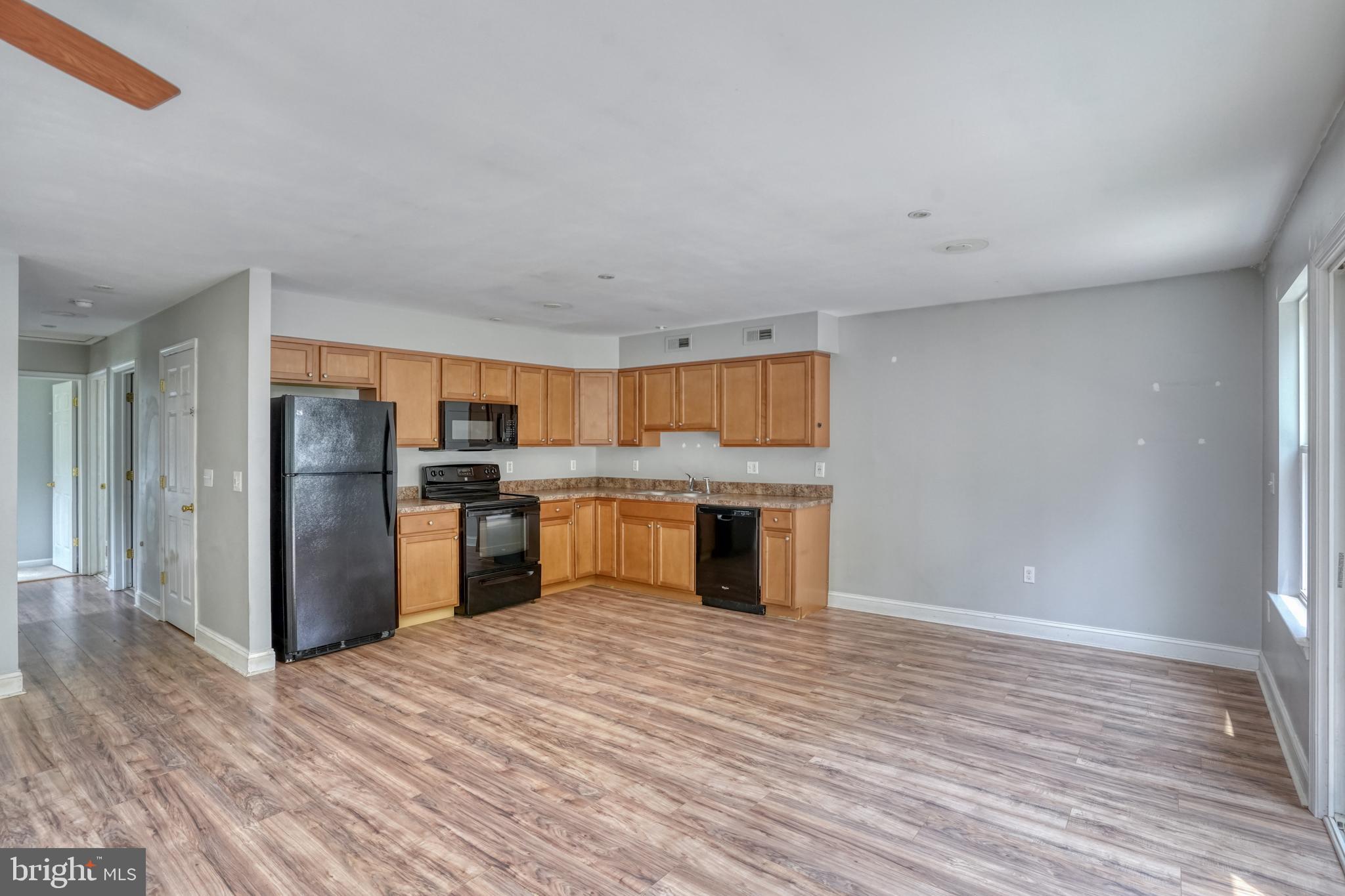 203 Hamilton Street Delaware City, DE 19706 - Photo 3 of 27 a kitchen with stainless steel appliances kitchen island granite countertop a refrigerator and a sink
