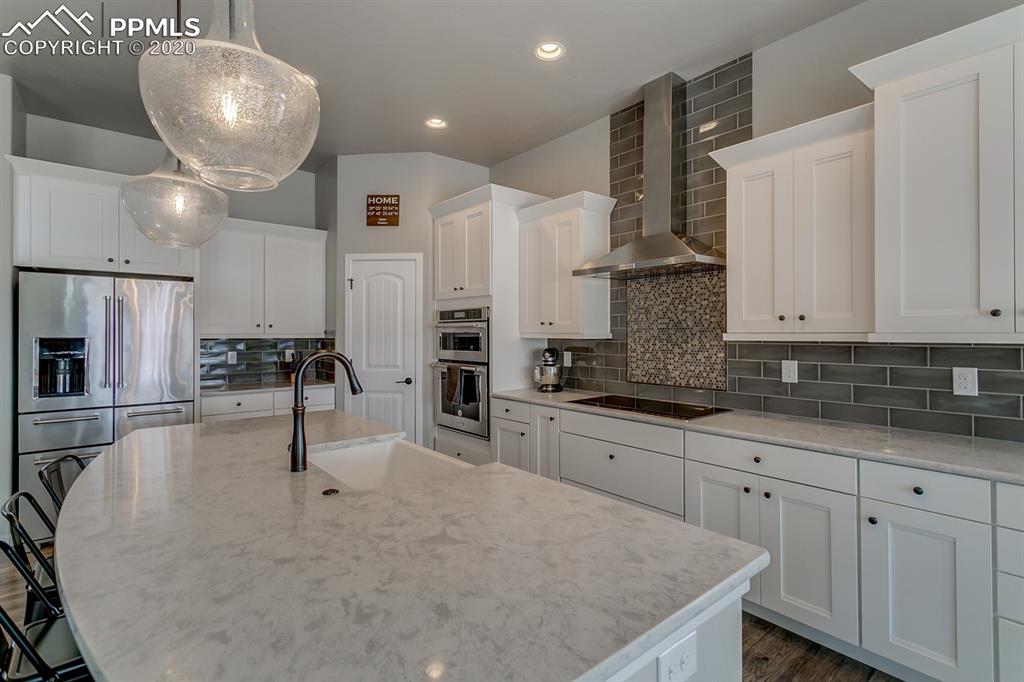 16430 Dancing Bear Lane Monument, CO 80132 - Photo 14 of 50 a kitchen with stainless steel appliances granite countertop a sink a stove and a refrigerator