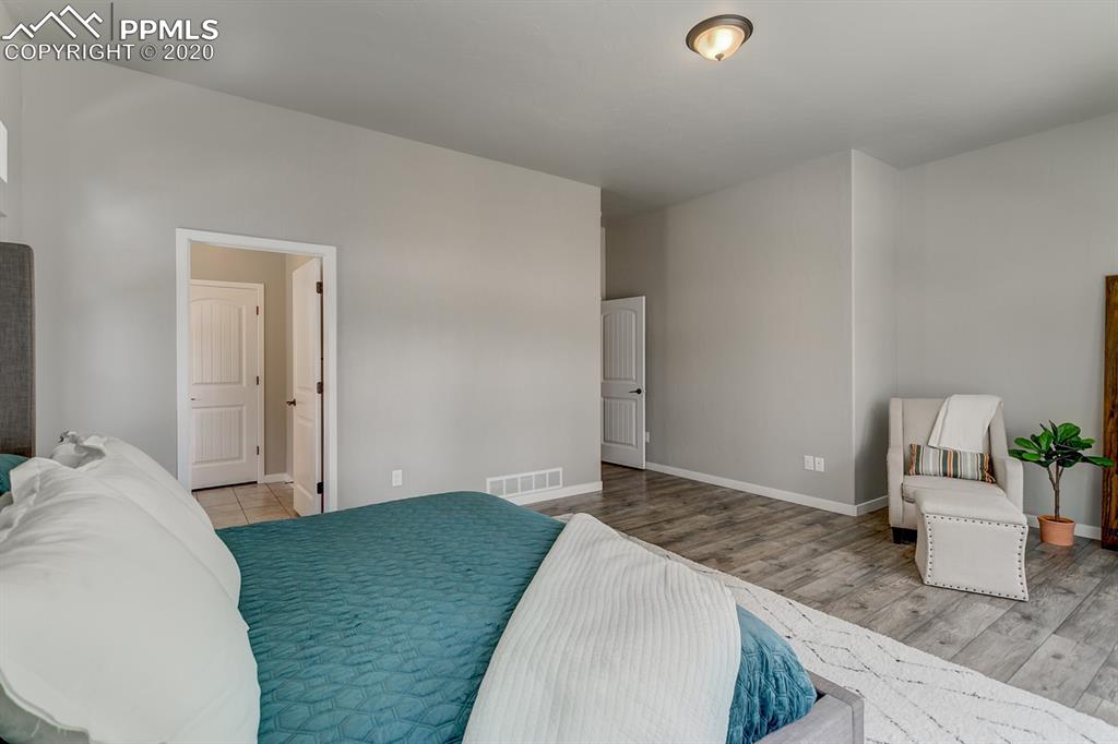 16430 Dancing Bear Lane Monument, CO 80132 - Photo 22 of 50 a bedroom with a granite countertop sink and cabinets