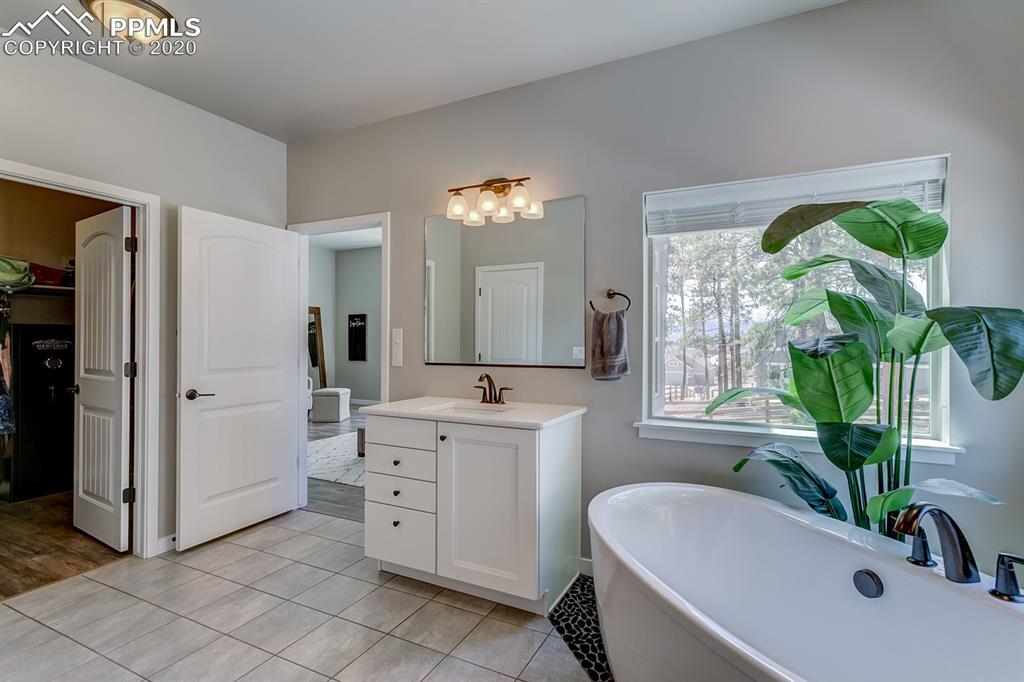 16430 Dancing Bear Lane Monument, CO 80132 - Photo 25 of 50 a bathroom with a tub sink and mirror