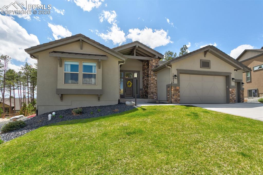 16430 Dancing Bear Lane Monument, CO 80132 - Photo 3 of 50 a front view of a house with a yard and garage