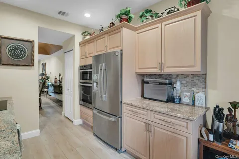 a kitchen with granite countertop a sink stainless steel appliances and cabinets
