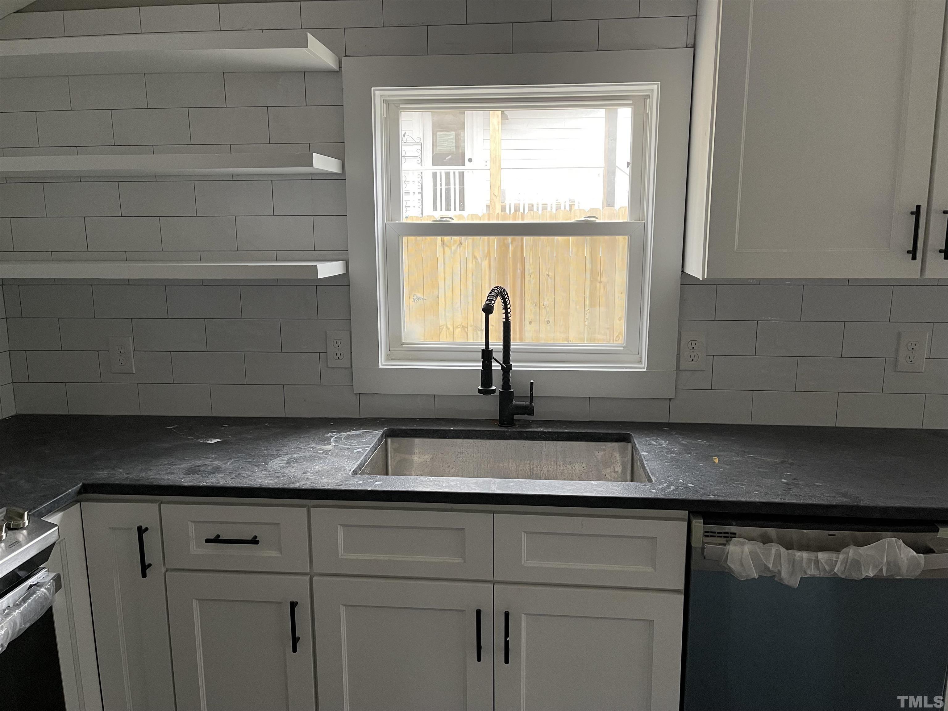 824 Coleman Street Raleigh, NC 27610 - Photo 3 of 30 a kitchen with granite countertop white cabinets and a window