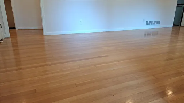 a view of a room with an empty space and wooden floor