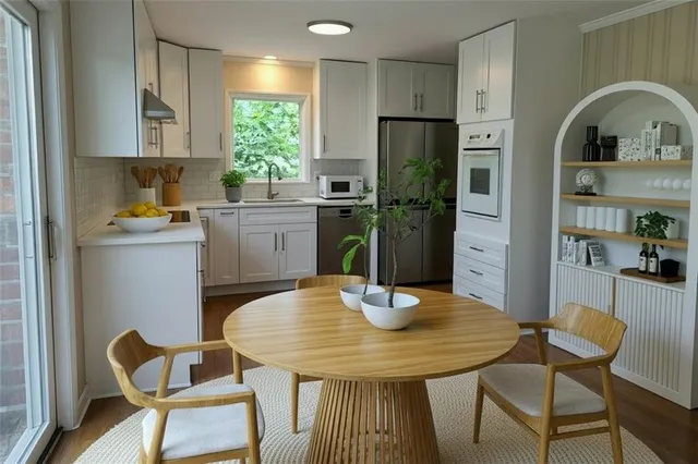 a kitchen with stainless steel appliances granite countertop a dining table and chairs