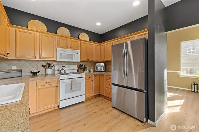 a kitchen with stainless steel appliances granite countertop a refrigerator sink and cabinets