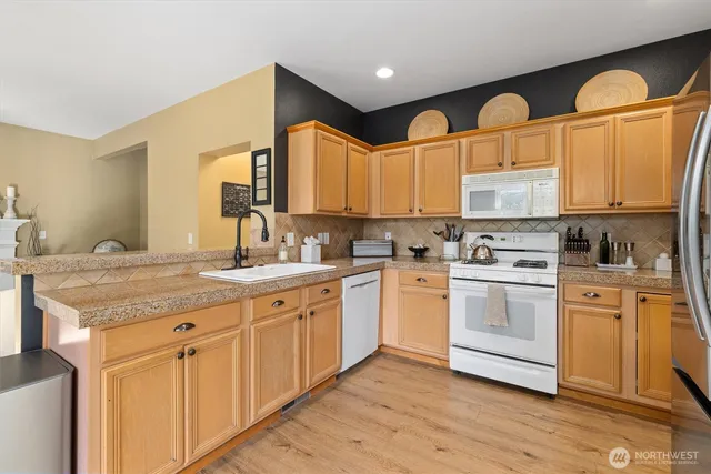 a kitchen with stainless steel appliances granite countertop a sink a stove and cabinets