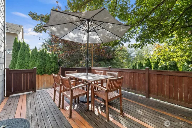 a patio with wooden floor a yard a table and chairs