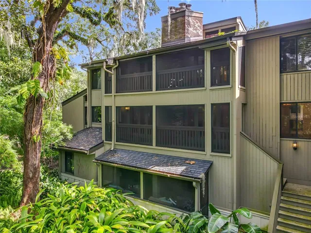 an aerial view of residential houses with outdoor space and trees