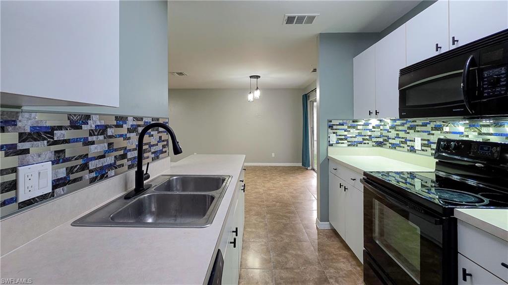 7319 Albany Road Fort Myers, FL 33967 - Photo 14 of 27 a kitchen with stainless steel appliances a sink a stove and a microwave