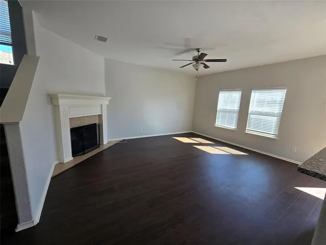 an empty room with windows fireplace and a sink