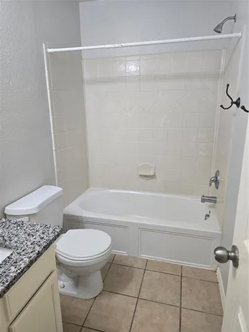 a bathroom with a granite countertop toilet a sink and a mirror