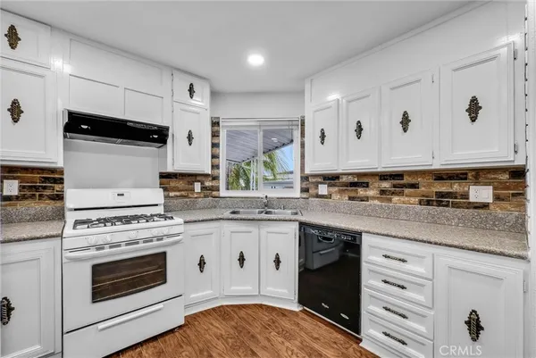 a kitchen with stainless steel appliances granite countertop a stove sink and cabinets